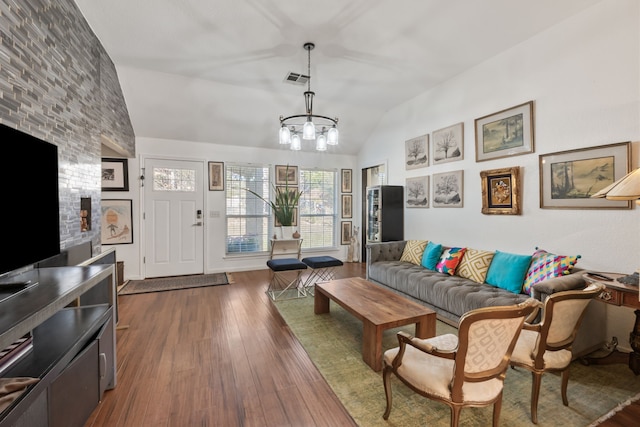 living room with an inviting chandelier, dark hardwood / wood-style flooring, and vaulted ceiling