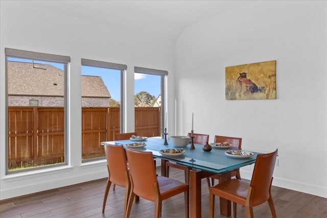 dining room with dark hardwood / wood-style floors and vaulted ceiling