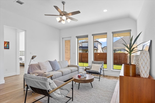 living room featuring light hardwood / wood-style floors, ceiling fan, a healthy amount of sunlight, and lofted ceiling