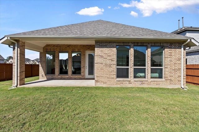 rear view of house with a patio and a yard