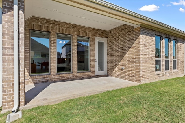 entrance to property with a patio and a yard