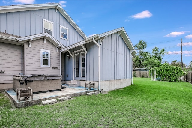 back of property featuring a patio area and a lawn