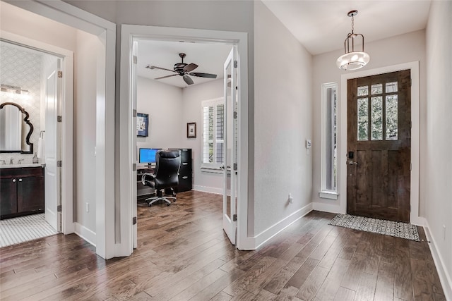 foyer with sink, ceiling fan with notable chandelier, and dark hardwood / wood-style floors