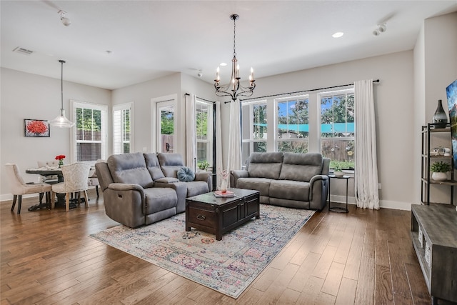 living room featuring dark hardwood / wood-style flooring and an inviting chandelier