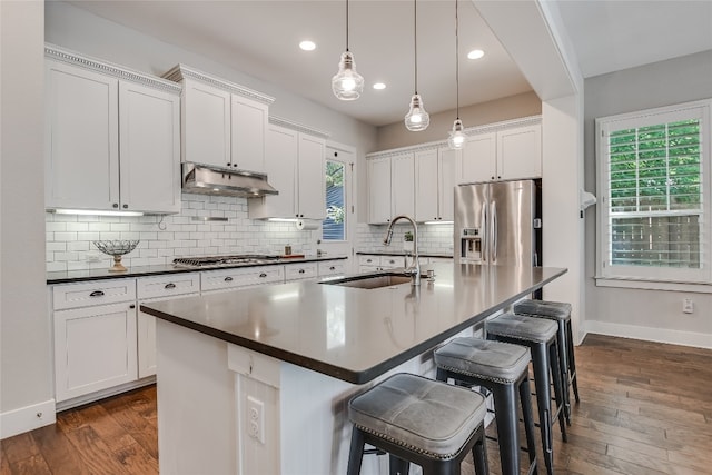 kitchen featuring white cabinetry, sink, dark hardwood / wood-style flooring, a center island with sink, and appliances with stainless steel finishes