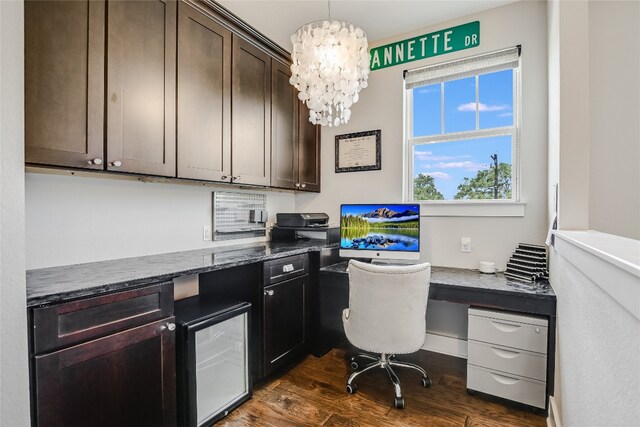 home office featuring built in desk, dark wood-type flooring, and a notable chandelier