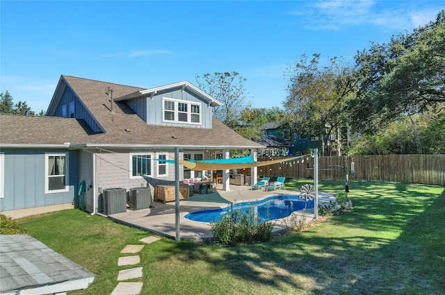 rear view of property with a lawn, a fenced in pool, a patio, and central AC