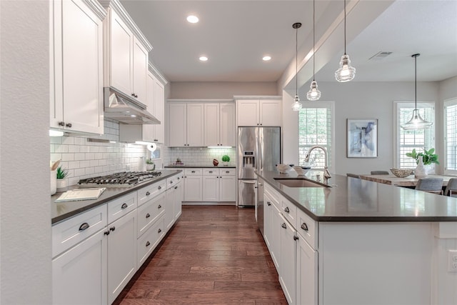 2717 Geraghty Ave, Austin, TX 78757 - kitchen featuring dark countertops, under cabinet range hood, appliances with stainless steel finishes, recessed lighting, and dark wood-type flooring