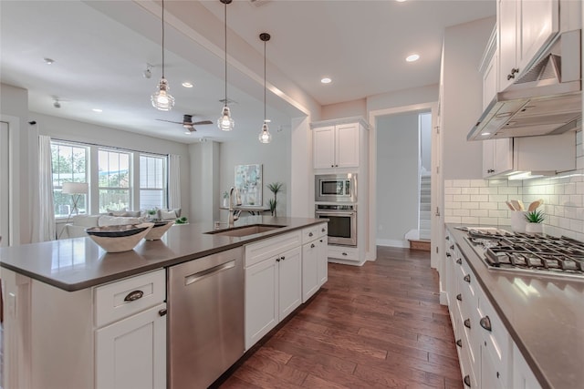 2717 Geraghty Ave, Austin, TX 78757 - kitchen with stainless steel appliances, dark countertops, dark wood-style floors, recessed lighting, and decorative backsplash