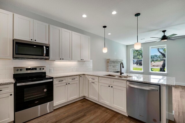 kitchen with appliances with stainless steel finishes, sink, and white cabinets