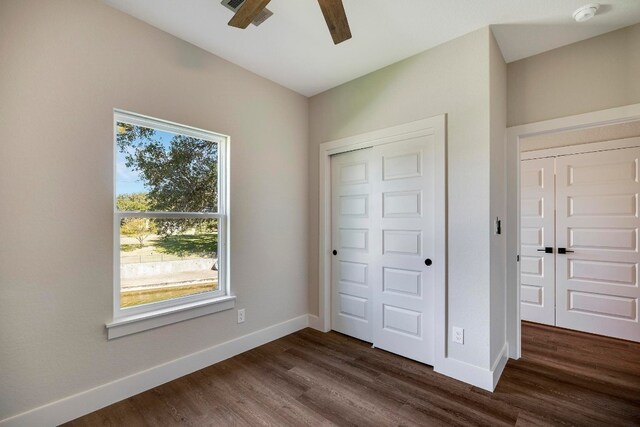 unfurnished bedroom with dark hardwood / wood-style flooring, ceiling fan, and a closet