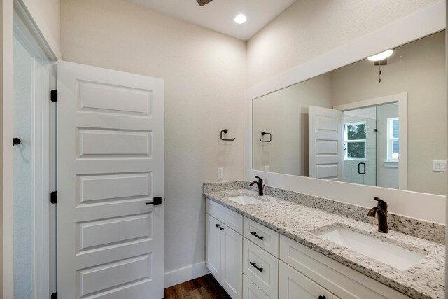 bathroom featuring hardwood / wood-style floors, a shower with door, and vanity