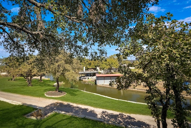 view of community featuring a lawn and a water view