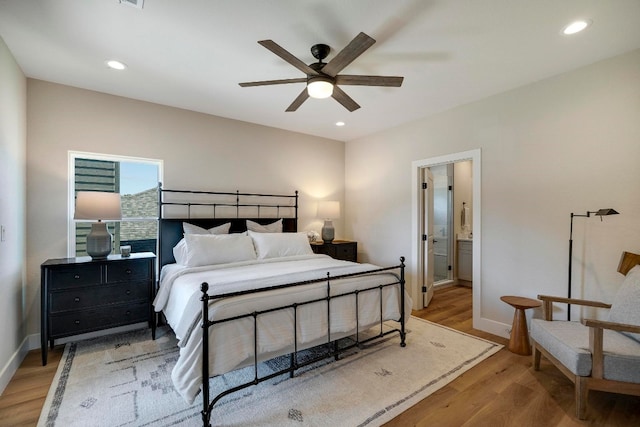 bedroom featuring ensuite bathroom, hardwood / wood-style floors, and ceiling fan