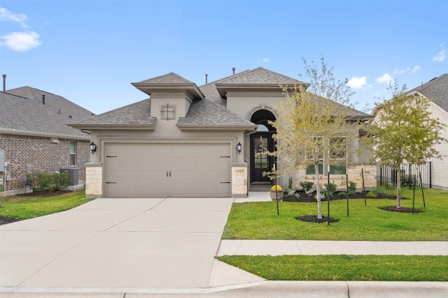 view of front of property featuring a garage, central air condition unit, and a front lawn