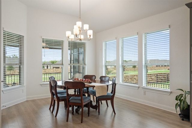 dining area with hardwood / wood-style flooring, a chandelier, and a healthy amount of sunlight