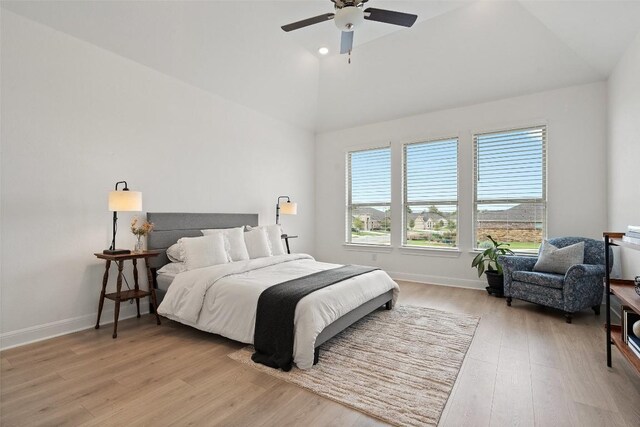 bedroom with ceiling fan, light hardwood / wood-style flooring, and lofted ceiling