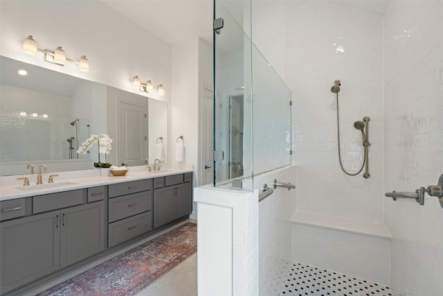 bathroom featuring vanity, tile patterned flooring, and a tile shower