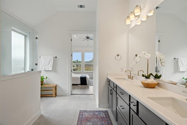 bathroom with a wealth of natural light, vanity, and vaulted ceiling