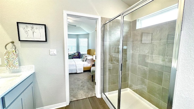 bathroom with a shower with door, vanity, and hardwood / wood-style flooring