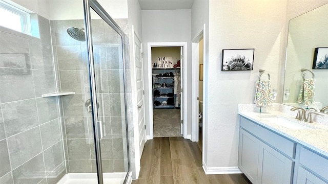 bathroom featuring hardwood / wood-style flooring, vanity, and a shower with door