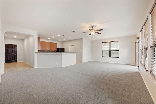 unfurnished living room with light carpet and ceiling fan