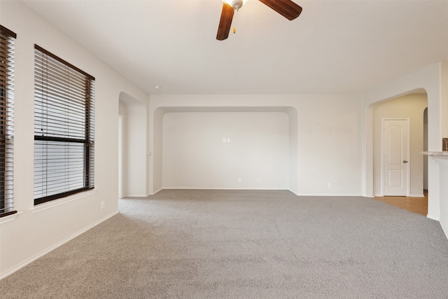 carpeted spare room with ceiling fan and plenty of natural light