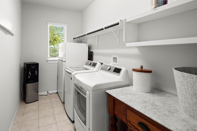 laundry area with light tile patterned floors and washer and dryer