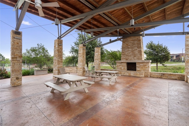 view of patio / terrace with ceiling fan and an outdoor stone fireplace