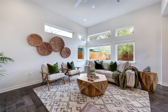 living room with hardwood / wood-style floors, a high ceiling, and ceiling fan