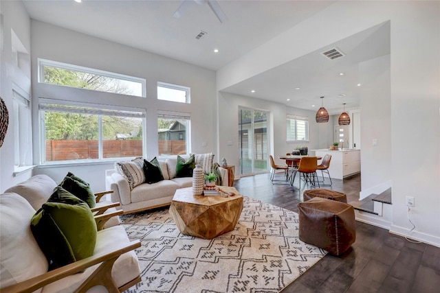 living room with a towering ceiling, ceiling fan, sink, and light hardwood / wood-style flooring