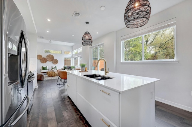 kitchen featuring a center island with sink, sink, stainless steel fridge with ice dispenser, dark hardwood / wood-style floors, and white cabinetry