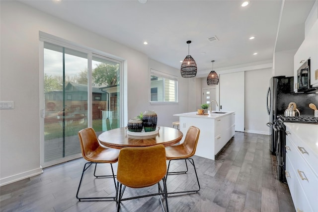 dining room featuring dark wood-type flooring, sink, and a notable chandelier