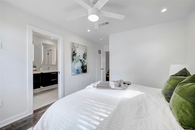 bedroom with wood-type flooring, ceiling fan, and ensuite bath