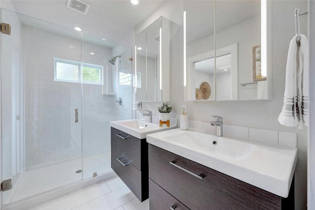 bathroom with vanity, an enclosed shower, and tile patterned flooring