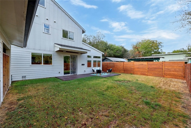 rear view of property with a yard and a patio area