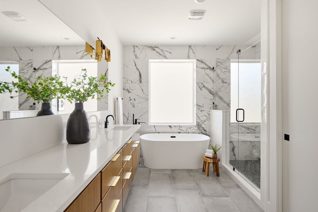 bathroom with tile walls, vanity, and separate shower and tub