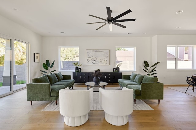 living room with light hardwood / wood-style flooring, ceiling fan, and plenty of natural light