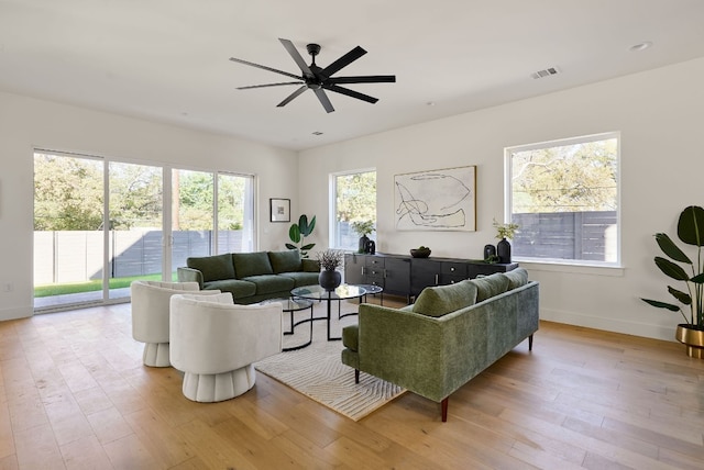 living room featuring a wealth of natural light, ceiling fan, and light hardwood / wood-style flooring