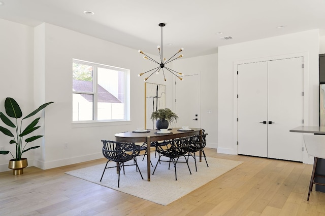 dining area featuring an inviting chandelier and light hardwood / wood-style flooring