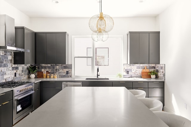 kitchen featuring gray cabinetry, stainless steel appliances, wall chimney range hood, sink, and decorative backsplash