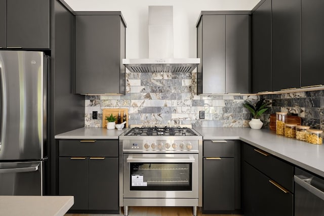 kitchen with gray cabinets, wall chimney exhaust hood, backsplash, and appliances with stainless steel finishes