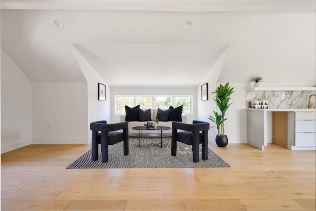 living room with light hardwood / wood-style flooring and vaulted ceiling