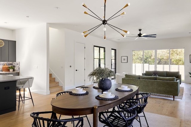 dining area featuring ceiling fan with notable chandelier and light hardwood / wood-style flooring