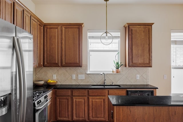 kitchen with stainless steel appliances, hanging light fixtures, sink, and tasteful backsplash