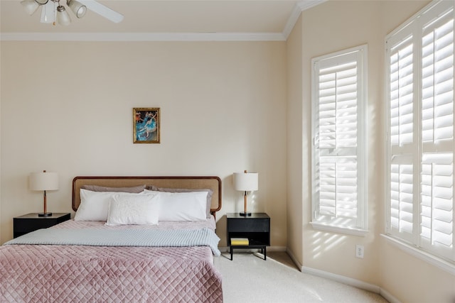 carpeted bedroom featuring ceiling fan and crown molding