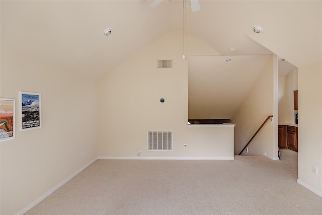 unfurnished living room featuring light carpet, ceiling fan, and vaulted ceiling