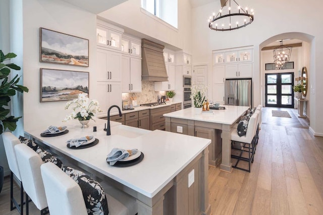 kitchen with a wealth of natural light, custom range hood, a kitchen bar, and a spacious island