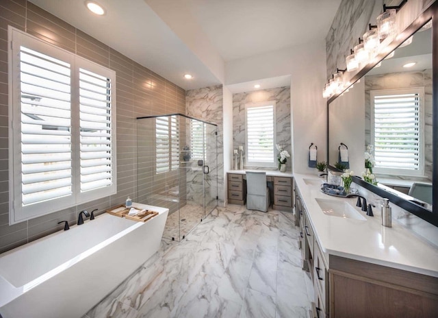 bathroom featuring tile walls, plenty of natural light, vanity, and separate shower and tub