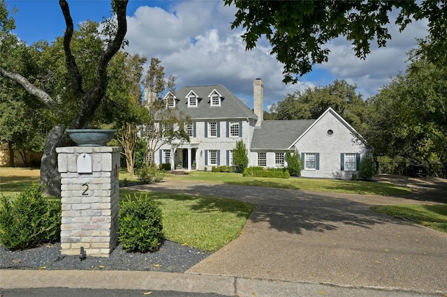 colonial inspired home with a front lawn